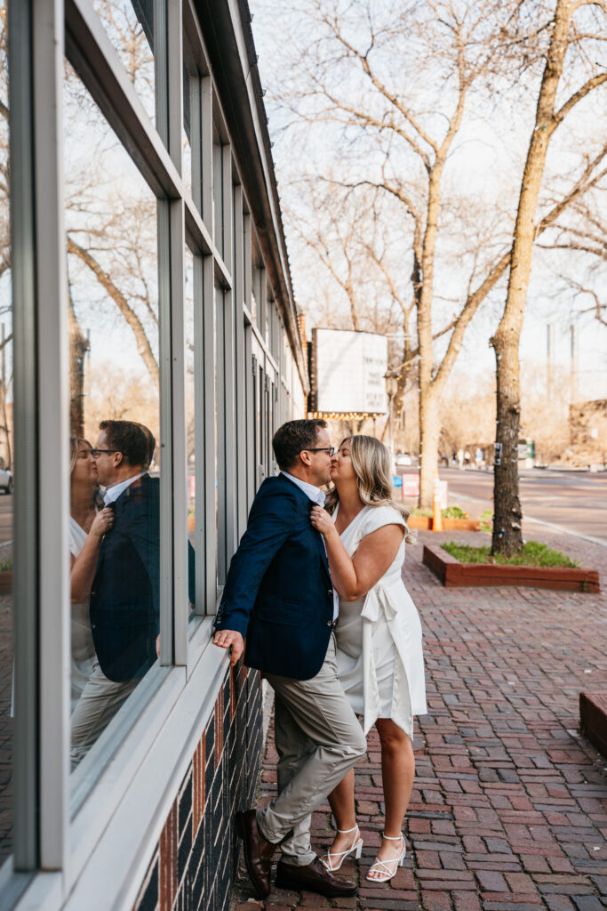 Couple kissing on the side walks in St. Anthony Main, Minneapolis. 