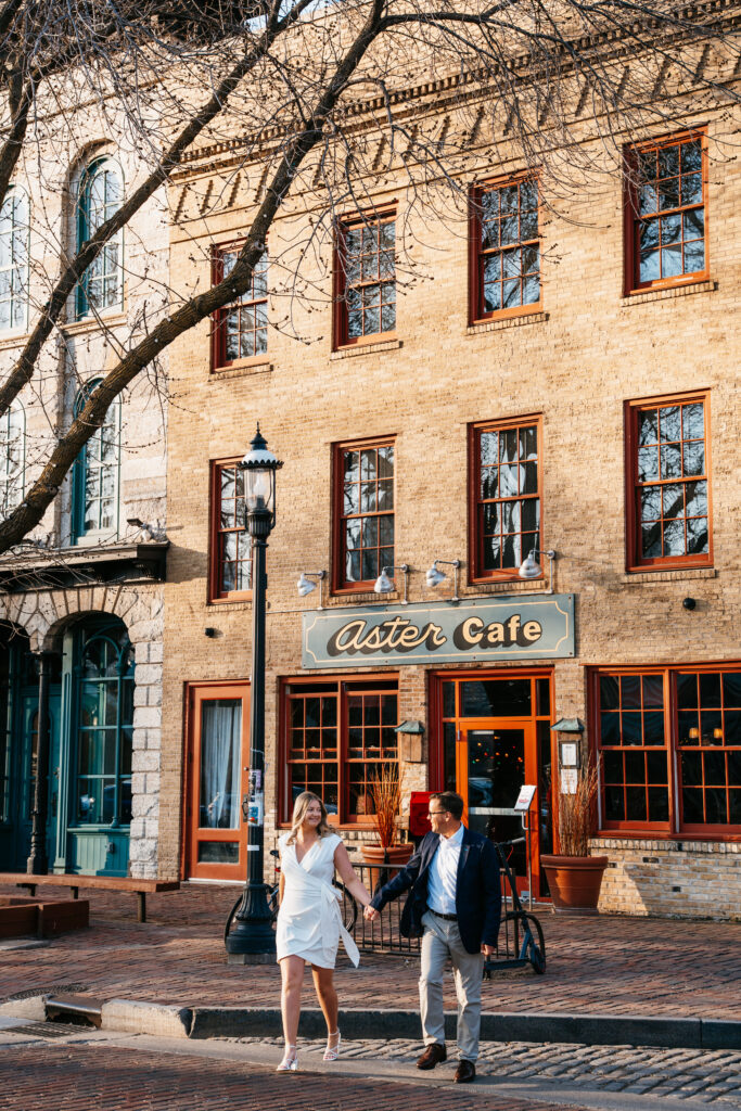 Photo of couple walking near Aster Cafe in  St. Anthony Main, Minneapolis. 