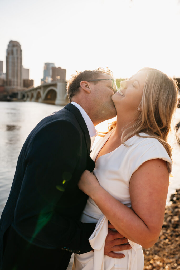 Couple kissing by the river in St. Anthony Main, Minneapolis. 