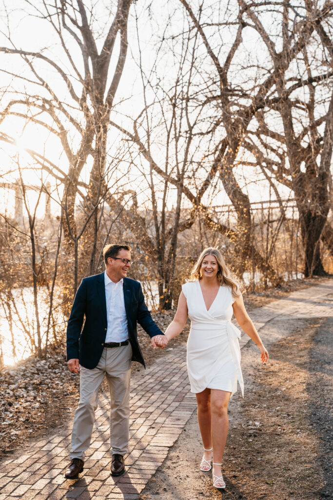 Photo of couple walking on side walk near the river in St. Anthony Main, Minneapolis. 