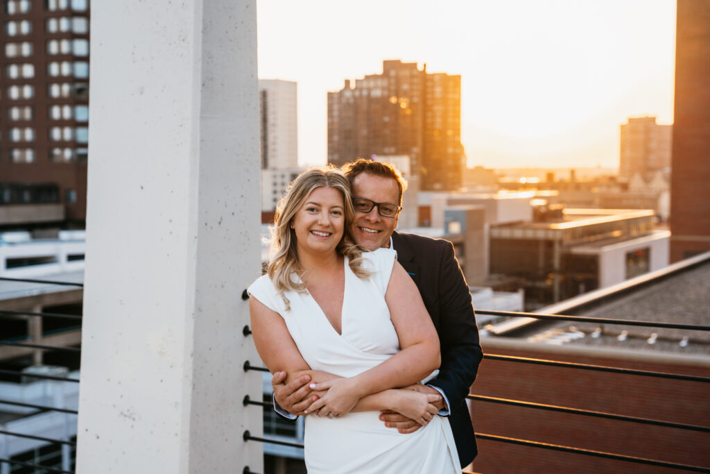 photo of couple standing on a parking ramp and hugging near St. Anthony Main, Minneapolis. 
