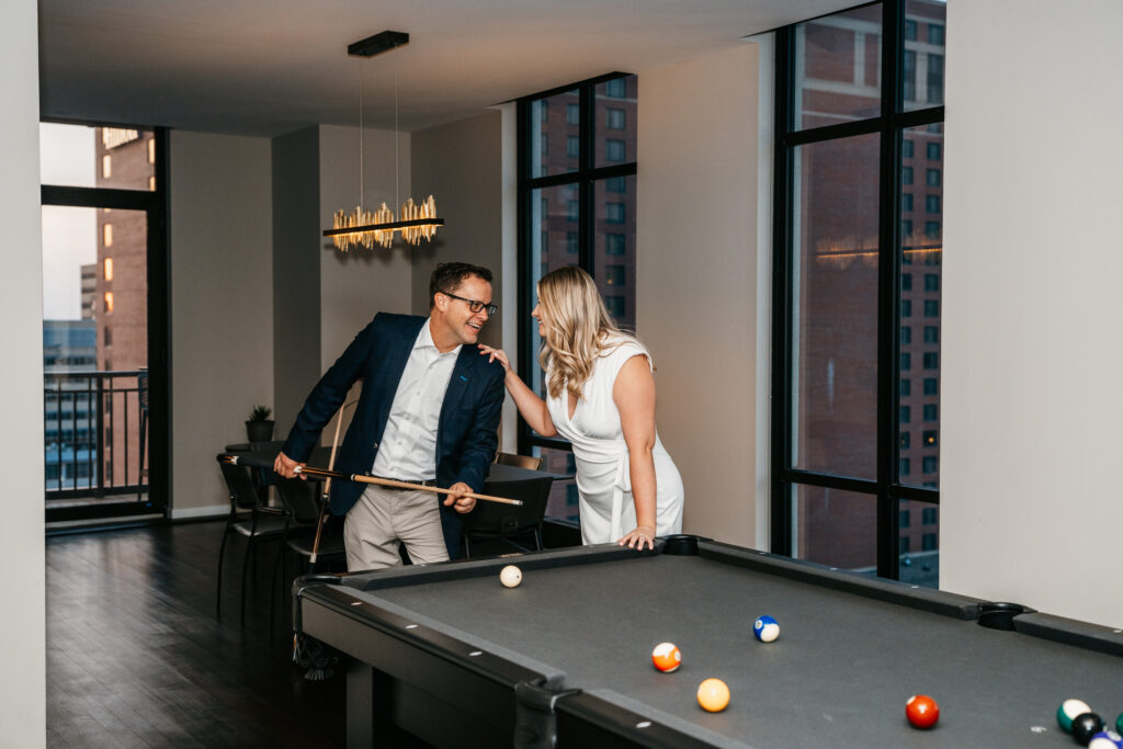 Couple is playing pool in their condo near St. Anthony Main, Minneapolis. 